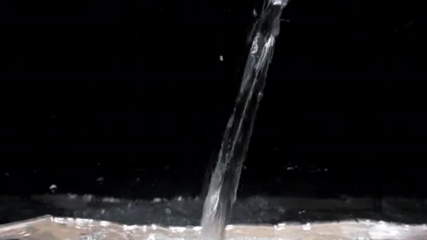 Ruisseau d'eau descend dans l'aquarium sur un fond noir isolé — Video