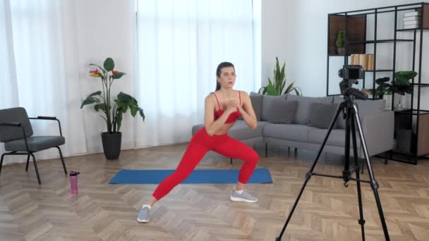 Blogger entrenadora de fitness mujer Fit haciendo ejercicio de calentamiento en el hogar moderno — Vídeos de Stock