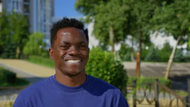 Portret glimlachend afro-Amerikaanse man etnische zwart op de achtergrond bomen in de zomer. — Stockvideo