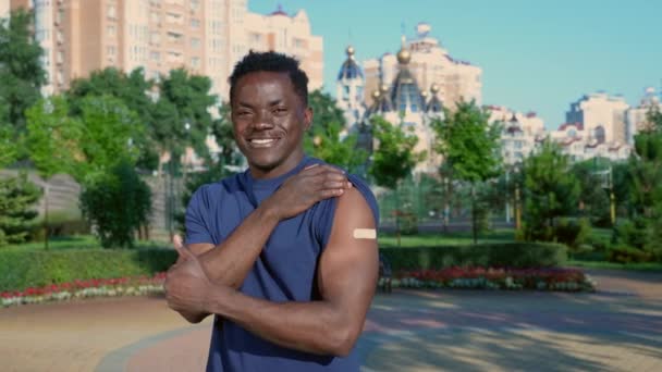 Pasien pria Afro-Amerika menunjukkan plaster medis menunjukkan suntikan vaksin. — Stok Video