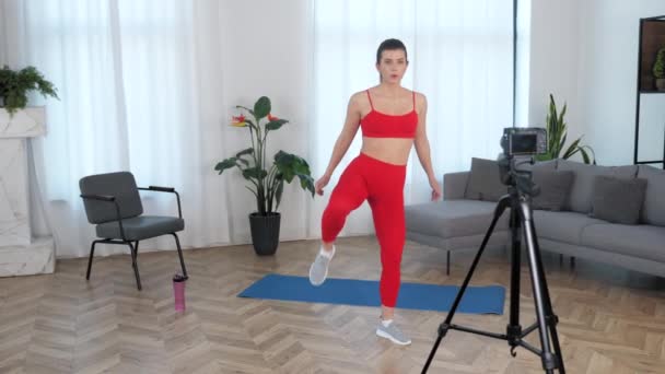 Formda kadın fitness eğitmeni blog yazarı evde egzersiz yapıyor. — Stok video