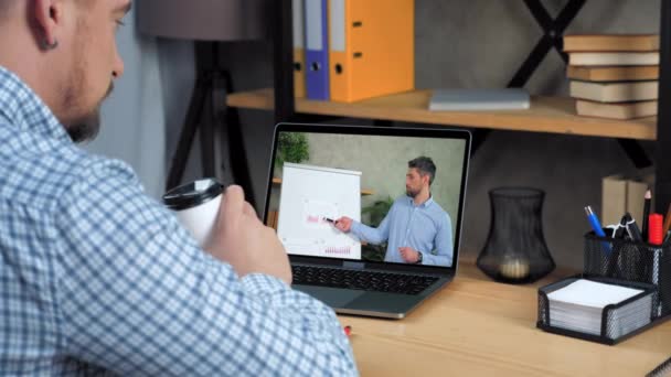 Üzletember az irodában néz online video hívás jelentés laptop, kávézás — Stock videók