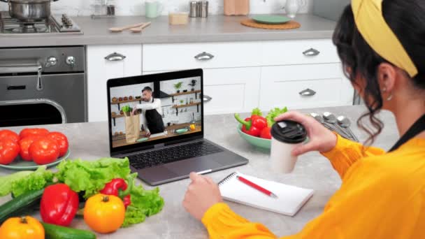 Man chef in laptop computer screen tells removes vegetables from paper bag — Stock Video