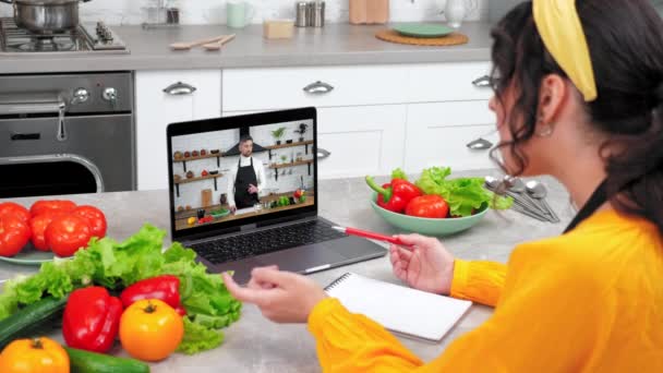 Mujer en casa cocina estudio en línea videollamada webcam portátil le dice a chef profesor — Vídeos de Stock