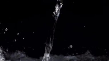 Akvaryumda yavaş hareket eden su akımı siyah bir arkaplanda düşer.