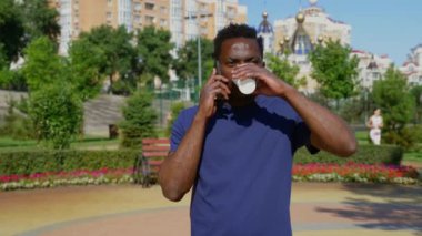 Portre Afro-Amerikalı adam cep telefonuyla konuşuyor Yazın kahve içiyor