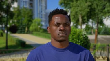 Afro-Amerikalı kendinden emin bir portre. Yetişkin etnik siyahlar parkta duruyor.