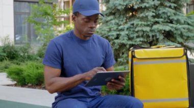 Afro-amerikan kurye teslimatında kamera yakınlaştırması tablet kullanıyor