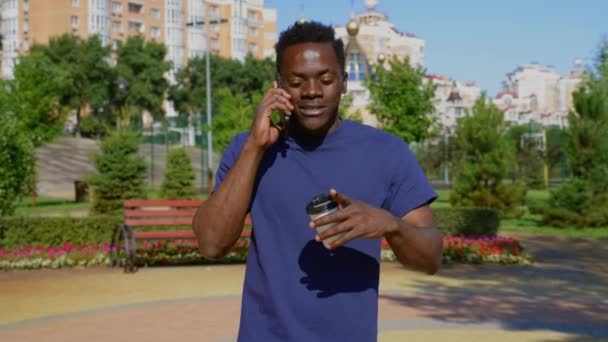 Retrato hombre afroamericano hablando por teléfono móvil bebiendo té de café en verano — Vídeos de Stock