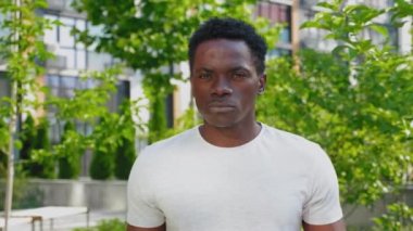 Amerikan bayrağını tutan Afro-Amerikan adam kameraya bakıyor.