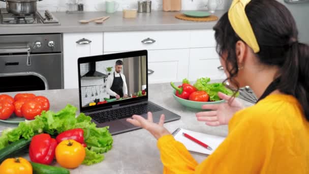 Mujer en casa cocina estudio en línea videollamada webcam portátil le dice a chef profesor — Vídeo de stock