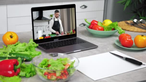 Computador portátil com homem chef comida blogger fatias tomate diz ensina alunos — Vídeo de Stock