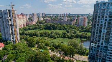 Drone aerial view marshy lake in the metropolis, summer nature in sunny day, green trees