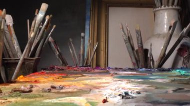 Sanat atölyesindeki sanat aletleri. Yaratıcı çalışma odasında yağlı boya. Fırçalar, boyalar, paletler, tuval, sehpa