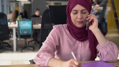 Türbanlı Müslüman iş kadını çok ırklı bir ekiple çalışıyor. Ofis Alanı ve Çalışma Alanı