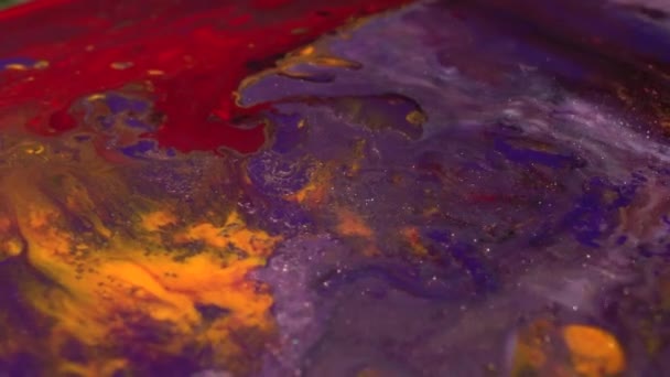 Purple, blue, red, orange and yellow colors mix. Paint movement macro. Moving flowing stream of liquid paint. Decorative abstract art background — Stockvideo