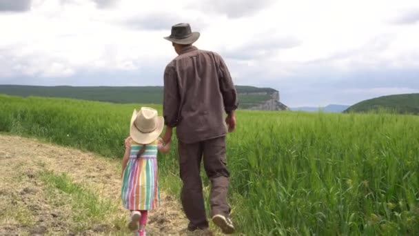 Farmer i jego córka idą pola pszenicy — Wideo stockowe
