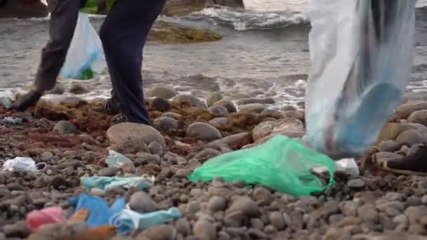 Vrijwilligers ruimen stranden aan de kust op. Afgedankte gezichtsmaskers zwerfstranden wereldwijd, bedreigen het zeeleven. Verkeerd gedumpt PBM doodt het mariene leven — Stockvideo