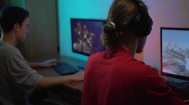 Genç erkek öğrencilerden oluşan bir takım eSport Oyuncuları geceleri oyun kulübünde rekabetçi video oyunlarında oynuyorlar.