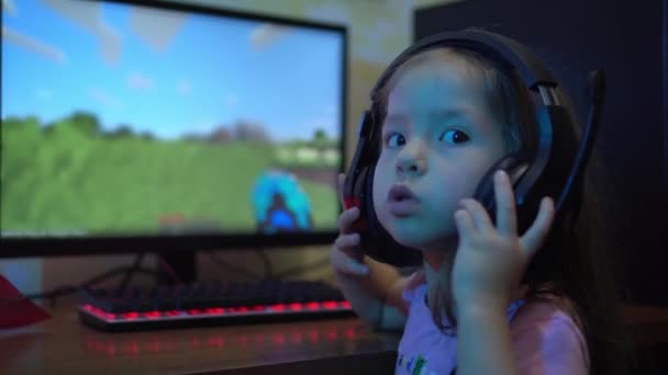 ヘッドフォンを持つ子供は、コンピュータ上でオンラインビデオゲームをプレイします。子供におけるコンピュータゲーム中毒の問題 — ストック動画