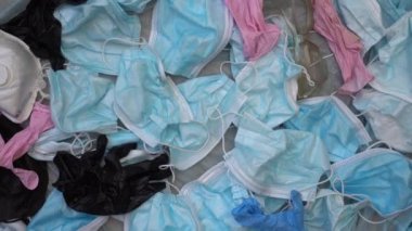 COVID-19 Atık Kirliliği krizi. Kullanılmış tek kullanımlık yüz maskeleri ve lateks eldivenler salgın sırasında okyanuslarda, bir çöp sahasında bulundu.