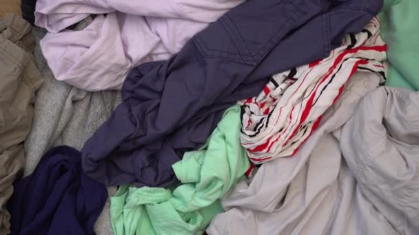 Ruha hulladék újrahasznosítás. Egy rakás használt ruha. Ártalmatlanítás, újrahasznosítás, adományozás, jótékonyság, használt — Stock videók