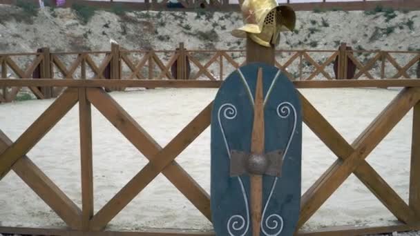 ローマのアリーナでグラディエーターのヘルメットと盾。グラディエーターとローマゲーム — ストック動画