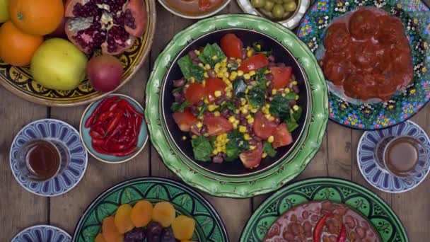Ид аль-Адха или праздник жертвоприношения. Праздничный стол с финиками, восточной едой и сладостями. Блюда, приготовленные из мяса жертвенного животного. Вид сверху — стоковое видео