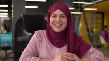 Tesettürlü gülümseyen müslüman kadının vesikalık fotoğrafını yakın çekimde bilgisayarda webcam dijital konferansı var. Müşteri ya da müşteriyle video konuşmasında mutlu etnik kadın konuşmaları