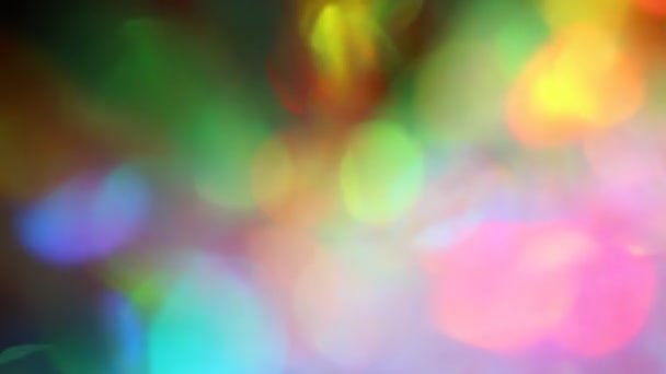 Multicolored highlights and bokeh. Light glowing through a crystal and a prism. Rainbow festive lights. Blurry abstract background — Vídeo de Stock