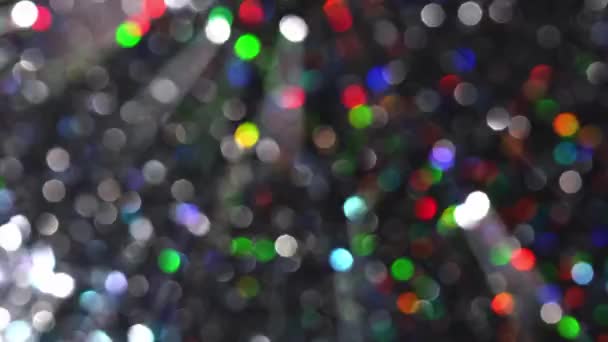 Meerkleurige magische lichten en bokeh. Regenboog feestelijke lichten. Wazige abstracte achtergrond. Feestelijke kerst glanzende sprankelende textuur — Stockvideo