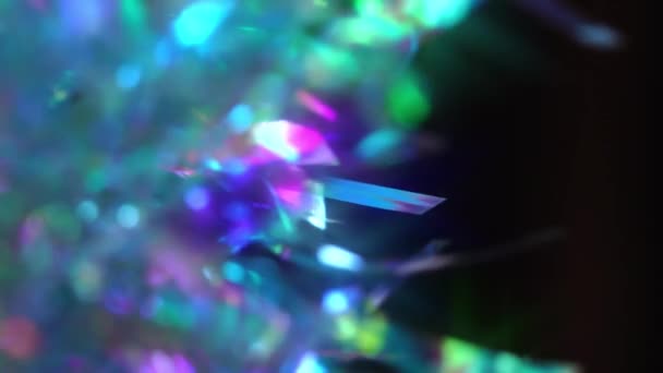 Prisma de cristal refractando la luz en colores vivos del arco iris. Diamante neón púrpura verde azulado decoración holográfica sobre fondo negro. Copiar espacio — Vídeos de Stock