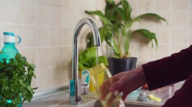Plastic free and zero waste life. Reusable water bottle. Man pours filtered water from the tap
