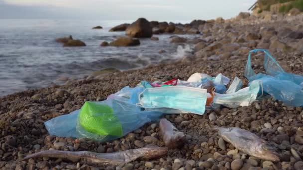 The Ocean Plastic Crisis. The coronavirus pandemic is polluting the worlds oceans. Disposable medical face masks and latex gloves washed up on the beach. Dead fish and underwater inhabitants — 图库视频影像