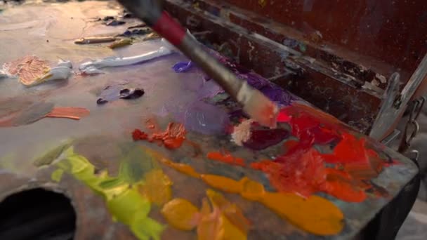 Art therapy and hobbies. The artist mixes oil paints on the palette with a brush — Vídeo de Stock