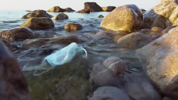 Coronavirus outbreak trash in the ocean. Disposable masks, medical gloves and used personal protective equipment. Plastic pollution threatening the health of oceans — Vídeo de Stock