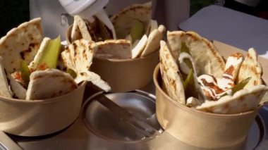 Falafel topları ve humus. Falafel geleneksel bir Ortadoğu yemeğidir. Genelde pide servis edilir. Falafel topları kızarıyor. Ateş açalım. Açık hava partisi. Kızarmış sokak yemekleri.