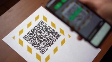 Covid-19 salgını sırasında QR kodu ve Temassız Ödemeler taranıyor. Bir adam, tüccarın hizmet parasını ödemek için kullandığı QR kodunu tarıyor.