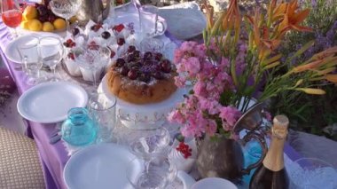 Lavanta tarlasında romantik yaz pikniği. Masanın üzerinde kek var.