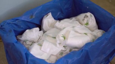 Çöpte kirli bebek bezleri. Kullanılmış bebek bezlerinden kurtulmak. Tek kullanımlık plastik ürünlerle çevre kirliliği sorunu