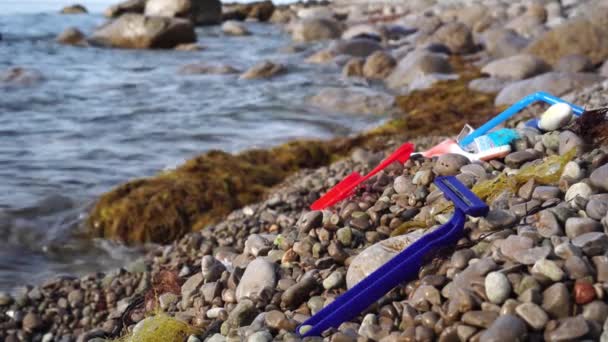 Pollution de l'océan par les déchets plastiques. Vieille brosse à dents usagée jetée dans un bord de mer. Déchets dans l'océan et la nature, environnement. Plastique immergé dans les océans — Video