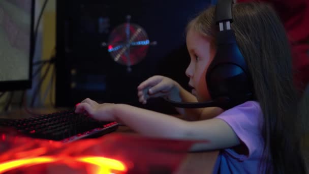 Un bambino con le cuffie gioca un videogioco online sul computer. Il problema della dipendenza da giochi per computer nei bambini. . Intrattenimento durante l'isolamento — Video Stock