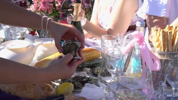 Picknick im Freien am Lavendelfeld mit Wein und Austern. Schöne Frauen frühstücken in der Natur — Stockvideo