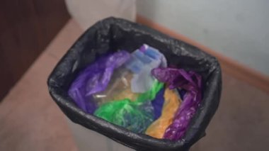 Bir kadın normal bir çöp kutusuna kırık kablolar atıyor. Eski elektronik eşyaların uygunsuz bir şekilde atılması, zehirli e-postalar, ev çöpleri. Çöp sahalarındaki ağır metaller. Çevre kirliliği