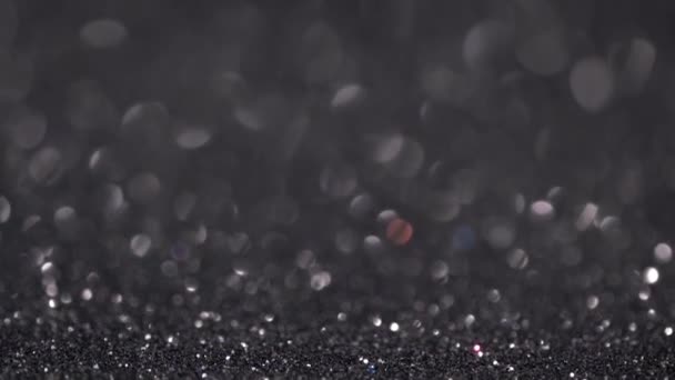 Abstract black glitter background with moving and flicker particles. Magic dust, metallic sequins, shiny texture, holiday lights, flying particles form a beautiful bokeh. Shining Christmas backdrop — Stock Video