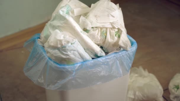 Des couches de bébé sales dans la poubelle. Jeter les couches usagées. Articles jetables d'hygiène personnelle et pollution de l'environnement — Video