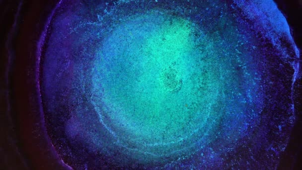 Ein Wirbel aus flüssiger blauer und schwarzer Farbe mit Neonbeleuchtung. Psychedelisch abstrakter Hintergrund. Glänzende Teilchen im All, Urknall, Götterauge, Universum, Galaxie, Nachthimmel — Stockvideo