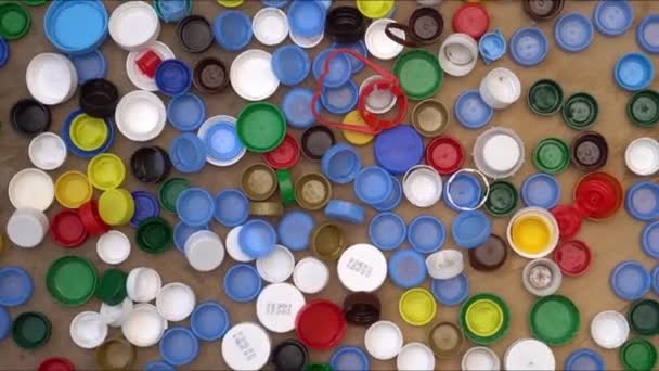 Tampas e tampas de garrafa de bebida de plástico usadas. Polipropileno 5, polietileno. Classificação e reciclagem de resíduos — Vídeo de Stock