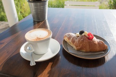 Kumsalda kahvaltı, makarna ve kapuçino.