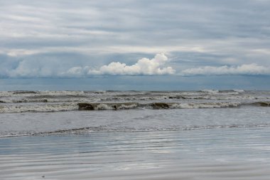 Kış deniz kıyısında bulutlar ve dalgalar